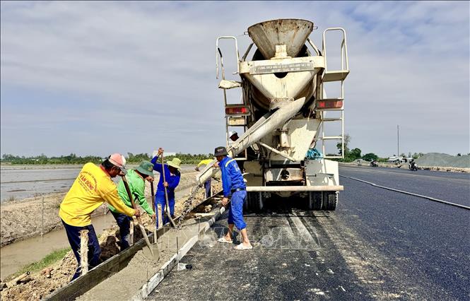 Công nhân tích cực thi công gờ thu nước mặt đường cao tốc đoạn qua tỉnh An Giang. Ảnh: Thanh Sang-TTXVN
