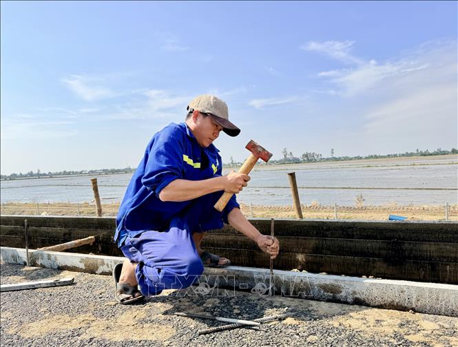 Công nhân tích cực thi công gờ thu nước mặt đường cao tốc. Ảnh: Thanh Sang-TTXVN
