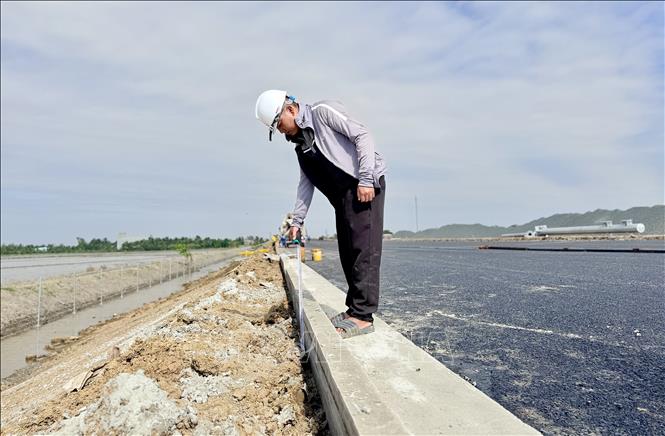 Công nhân đo kiểm tra kích thước gờ thu nước mặt đường cao tốc. Ảnh: Thanh Sang-TTXVN
