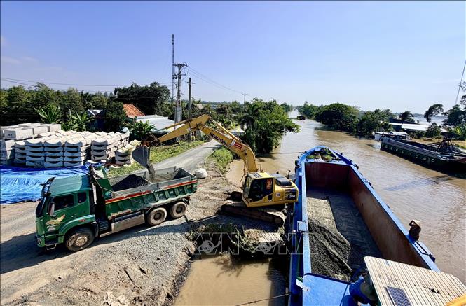 Xe tải vận chuyển vật liệu từ sà lan phục vụ thi công cao tốc. Ảnh: Thanh Sang-TTXVN