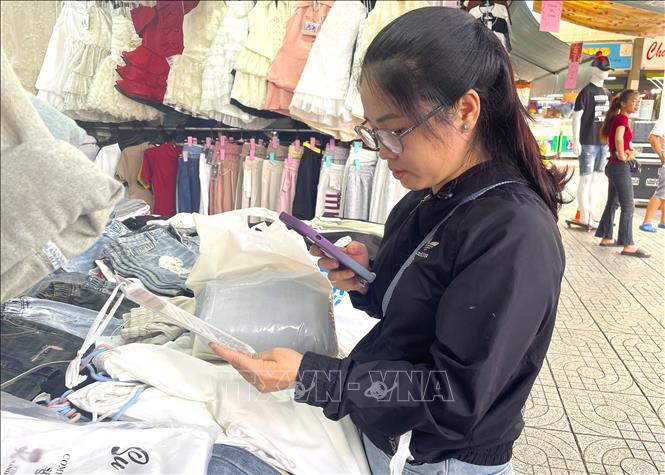Người dân quét mã thanh toán tiền khi đi chợ, tại chợ Phạm Văn Hai, TP. Hồ Chí Minh. Ảnh: Hương Giang – TTXVN 