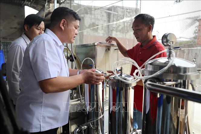 Đại diện Chi cục Phát triển nông thôn Thành phố Hồ Chí Minh kiểm tra máy móc, thiết bị trước khi bàn giao hỗ trợ Hợp tác xã nước mắm cá cơm nguyên chất Hải Đăng, phường Phước Thắng. Ảnh: Hoàng Nhị - TTXVN