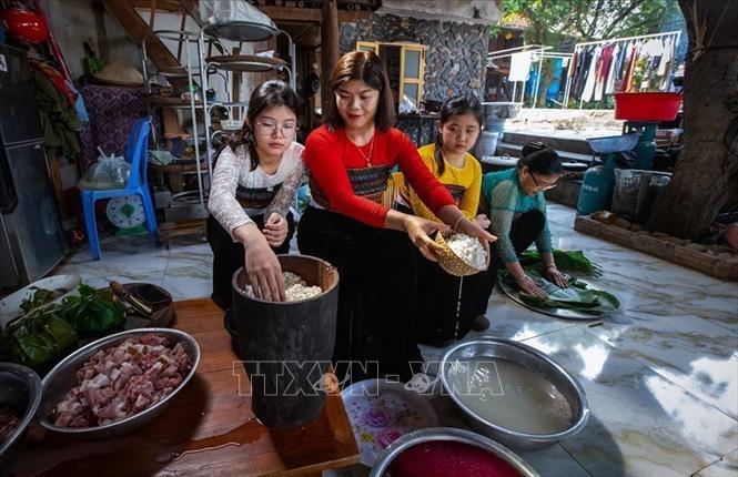 Khi lúa bắt đầu vào độ chín vàng, người phụ nữ Thái sẽ chọn những bông lúa đẹp nhất ở thửa ruộng tốt nhất, mang về treo gác bếp. Khi mùa màng gặt xong, họ mới đạp thóc, giã gạo, đồ xôi để làm lễ. Ảnh: Trọng Đạt - TTXVN
