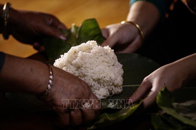 Xôi sau khi chín được quạt nguội rồi gói thành những gói nhỏ vuông vức bằng lá dong. Ảnh: Trọng Đạt - TTXVN