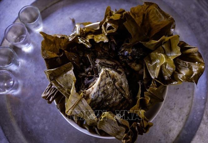 Cá hấp được gói trong lá dong, buộc lạt giang, hấp trong khoảng một giờ – món ăn đặc trưng của người Thái. Ảnh: Trọng Đạt - TTXVN