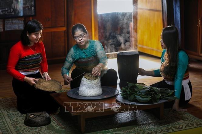 Xôi sau khi chín được quạt nguội rồi gói thành những gói nhỏ vuông vức bằng lá dong. Cách gói này giúp xôi giữ nguyên độ dẻo thơm, đồng thời dễ bày lên mâm cúng. Ảnh: Trọng Đạt - TTXVN