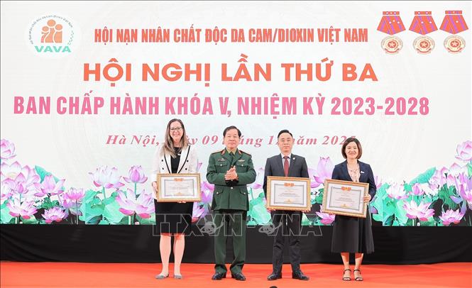 Trung Tướng Nguyễn Hữu Chính, Chủ tịch Hội Nạn nhân chất độc da cam/dioxin Việt Nam tặng bằng khen cho các tổ chức, cá nhân đã có nhiều đóng góp tích cực hỗ trợ nạn nhân chất độc da cam/dioxin Việt Nam. Ảnh: Lê Đông - TTXVN