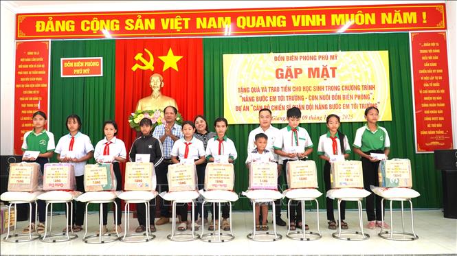 Nhà tài trợ trao quà cho học sinh. Ảnh: Văn Sĩ - TTXVN