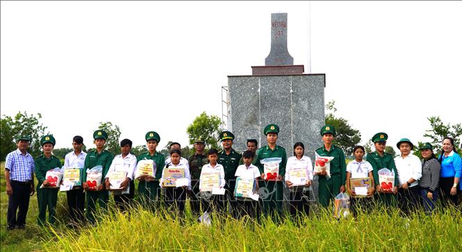 Tại cột mốc 303, Ban tổ chức trao quà cho các học sinh ở huyện Kampong Trach, tỉnh Kampot (Vương quốc Campuchia) thuộc chương trình “Nâng bước em tới trường - Con nuôi Đồn Biên phòng”. Ảnh: Văn Sĩ - TTXVN