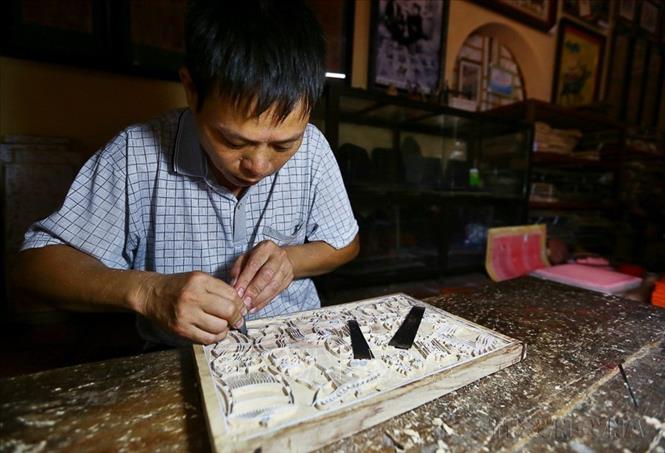 Sáng tác mẫu tranh và khắc ván là khâu sáng tạo quan trọng nhất của quy trình làm tranh Đông Hồ, quyết định sự sinh tồn của một làng tranh, đòi hỏi năng khiếu bẩm sinh và kỹ năng lao động cao ở các nghệ nhân. Ảnh: Minh Quyết – TTXVN