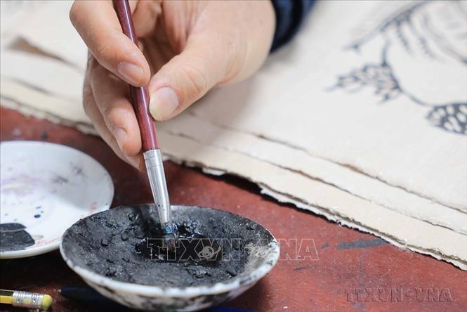 Mực màu trên tranh Đông Hồ đều được làm từ nhiên liệu tự nhiên, như màu vàng của hoa hòe, màu đỏ của hoa hiên, màu trắng từ bột vỏ sò, điệp và màu đen của than lá tre (2025). Ảnh: Hoàng Hiếu - TTXVN