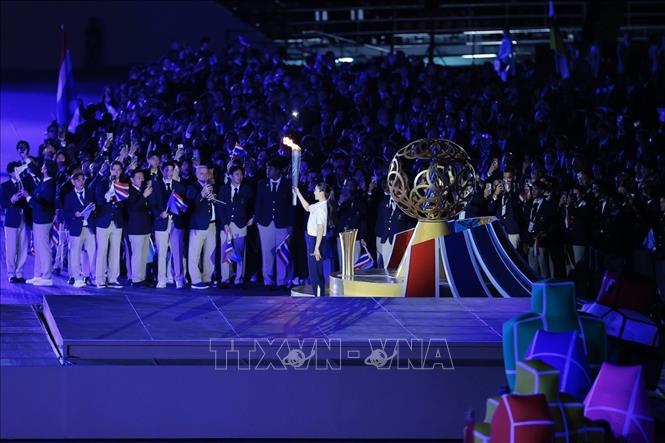 Cựu nữ võ sĩ taekwondo Panipak Wongpattanakit từng giành huy chương vàng Olympic Tokyo 2020 và Paris 2024 thực hiện nghi thức thắp sáng đài lửa SEA Games 33. Ảnh: Minh Quyết - PV TTXVN từ Thái Lan