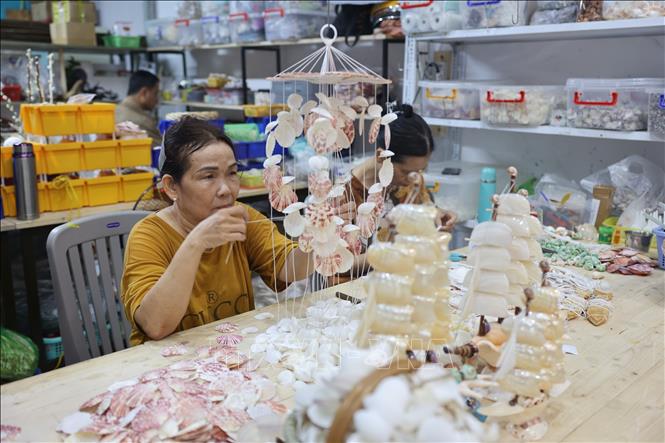 An artisan crafts products from seashells. VNA Photo: Hoàng Nhị 