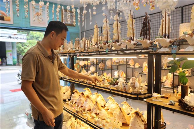 Mr. Nguyen Thanh Vu, owner of Thanh Them shell handicraft production facility (Vung Tau ward, Ho Chi Minh City) checks the product. VNA Photo: Hoàng Nhị 