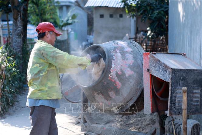Ông Hoàng Văn Cán ở bản Nà Củng, xã biên giới Phong Thổ (Lai Châu), tự phụ giúp anh em họ hàng cùng xây nhà để giảm chi phí xây dựng. Ảnh: Việt Dũng - TTXVN 