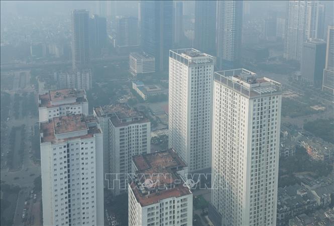 Nhiều toà nhà cao tầng khu Cầu Giấy, Hà Nội, chìm trong bụi mịn và sương mù dày đặc sáng 10/12/2025. Ảnh: Phan Phương – TTXVN