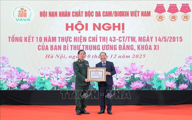 Ông Vi Tư Liệu, Vụ trưởng Vụ Đoàn thể nhân dân, Ban Tuyên giáo và Dân vận Trung ương trao bằng khen của Ban Tuyên giáo và Dân vận Trung ương cho Hội nạn nhân chất độc da cam/dioxin Việt Nam. Ảnh: Lê Đông - TTXVN