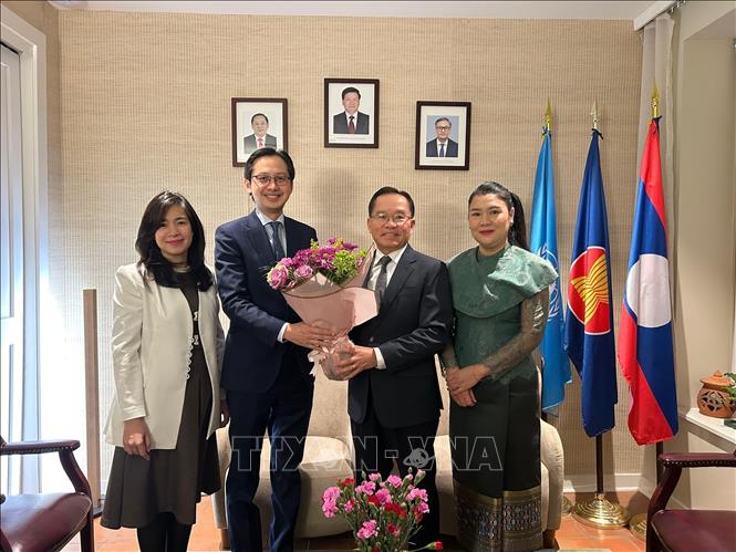 Đại sứ Đỗ Hùng Việt cùng Phu nhân chúc mừng Đại sứ Thongphane Savanphet và Phu nhân cùng toàn thể cán bộ, nhân viên Phái đoàn Lào tại LHQ. Ảnh: Thanh Tuấn - PV TTXVN tại Mỹ