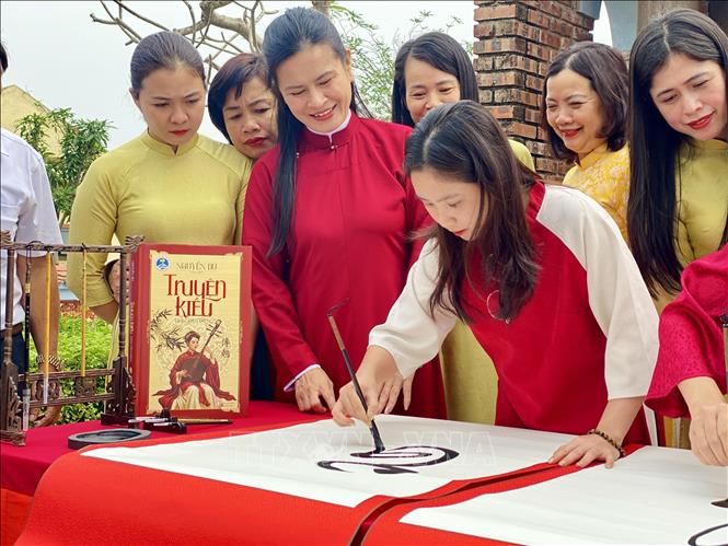 Nghệ nhân thực hiện viết Truyện Kiều bằng thư pháp. Ảnh: Hữu Quyết - TTXVN