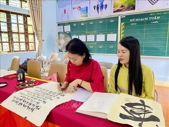 Các giáo viên tại trường Tiểu học Tiên Điền tham gia viết Truyện Kiều bằng thư pháp. Ảnh: Hữu Quyết - TTXVN