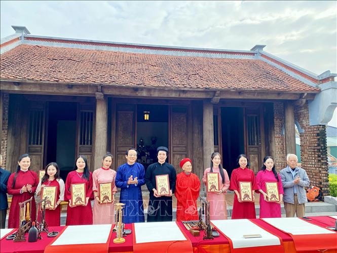 Trao tặng Truyện Kiều ấn bản Tiên Điền cho các nghệ nhân tham gia viết thư pháp. Ảnh: Hữu Quyết - TTXVN