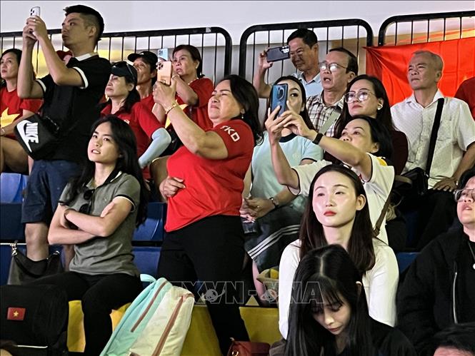 Cô Lâm Thị Hoài Thới (thứ 3, trái sang), mẹ của võ sĩ Nguyễn Thị Kim Hà, HCB nội dung biểu diễn quyền đôi nam nữ tiêu chuẩn cổ vũ cho đội tuyển Việt Nam. Ảnh: Đỗ Sinh – PV TTXVN tại Thái Lan