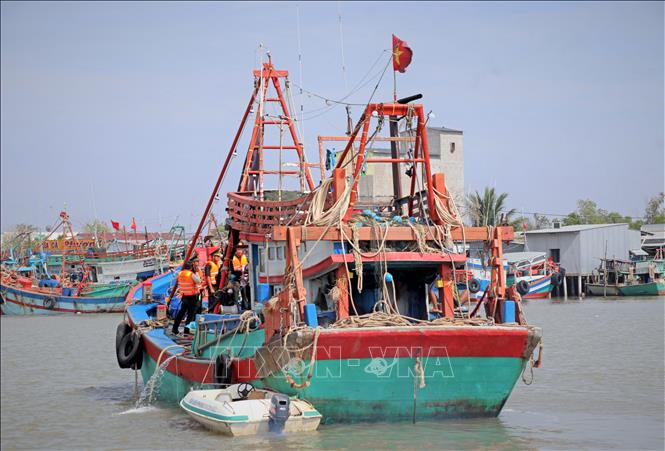 Cán bộ, chiến sĩ Đồn Biên phòng Rạch Gốc đến tận tàu để tuyên truyền, giải thích cụ thể về các quy định chống khai thác IUU cho ngư dân. Ảnh: Huỳnh Anh - TTXVN