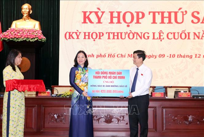 Đại diện Ủy ban MTTQ Việt Nam Thành phố Hồ Chí Minh tiếp nhận tiền quyên góp tại Kỳ họp từ các đại biểu HĐND Thành phố ủng hộ đồng bào bị bão lụt. Ảnh: Xuân Khu-TTXVN