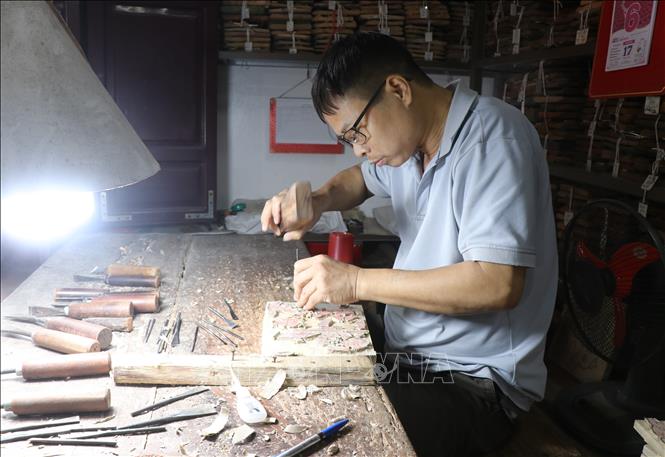 Khắc ván khắc gỗ tranh dân gian Đông Hồ. Ảnh: Thanh Thương - TTXVN
