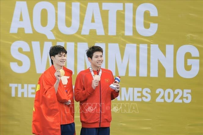 Tran Hung Nguyen (L) storms to his fourth consecutive SEA Games gold in the men’s 200m individual medley while Nguyen’s teammate Nguyen Quang Thuan grabs a bronze. VNA Photo: Minh Quyết