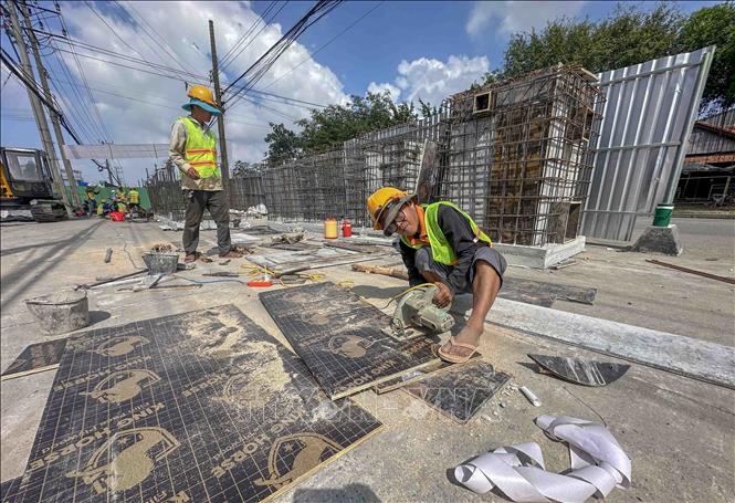 Công nhân thi công các cấu kiện đúc sẵn của hệ thống thoát nước dự án mở rộng Quốc lộ 91. Ảnh: Thanh Liêm - TTXVN