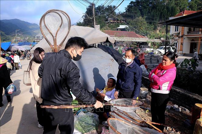 Người dân vùng cao Lũng Vân buôn bán các vật dụng được làm thủ công để bán ở phiên chợ. Ảnh: Thanh Hải - TTXVN 