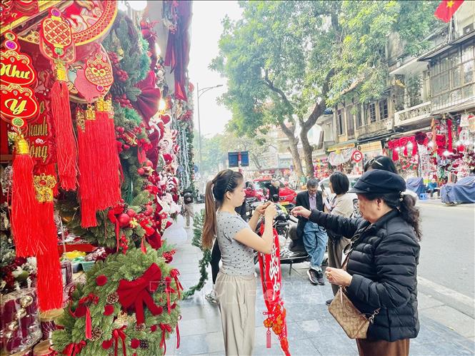 Khách hàng mua sắm đồ trang trí cây thông Nole trên phố Hàng Mã, Hà Nội. Ảnh: Tuyết Mai - TTXVN 