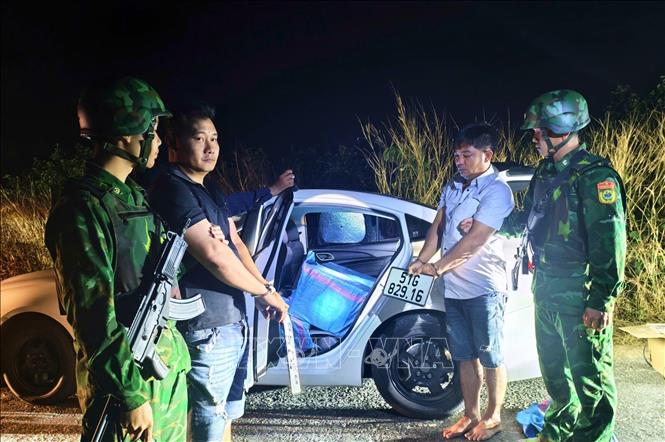 Rạng sáng 10/12, Lực lượng chức năng bắt giữ đối tượng Lê Hùng Cường và Nguyễn Hoàng Tuấn đang sử dụng ô tô 4 chỗ vận chuyển hơn 210 kg pháo lậu. Ảnh: TTXVN phát