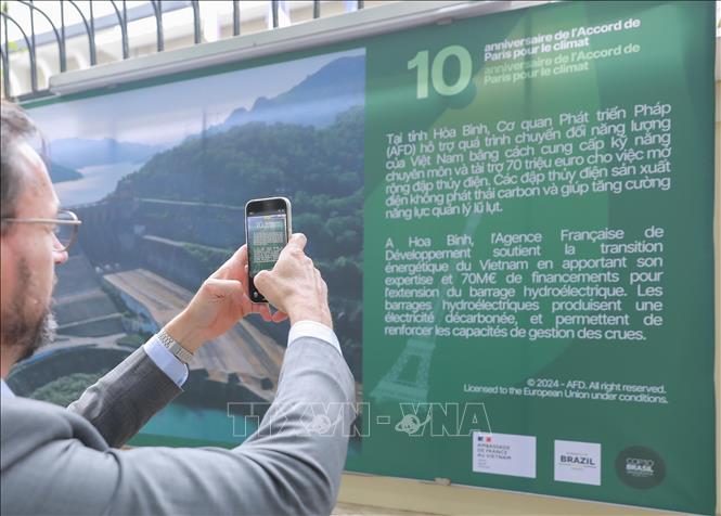 Hoạt động trưng bày ảnh tái hiện 10 năm Hiệp định Paris và sự đồng hành của Pháp với Việt Nam ứng phó khí hậu. Ảnh: Phan Phương - TTXVN