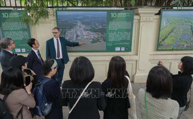 Đại sứ Pháp tại Việt Nam Olivier Brochet giới thiệu bộ ảnh kỷ niệm 10 năm Hiệp định Paris với du khách. Ảnh: Phan Phương – TTXVN