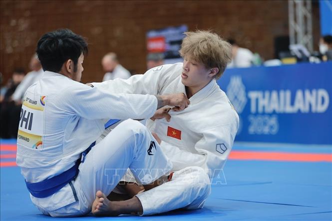 VĐV Nguyễn Tiến Triển (đai đỏ, Việt Nam) thi đấu nội dung Ne-waza hạng 85kg. Ảnh: Minh Quyết - PV TTXVN tại Thái Lan