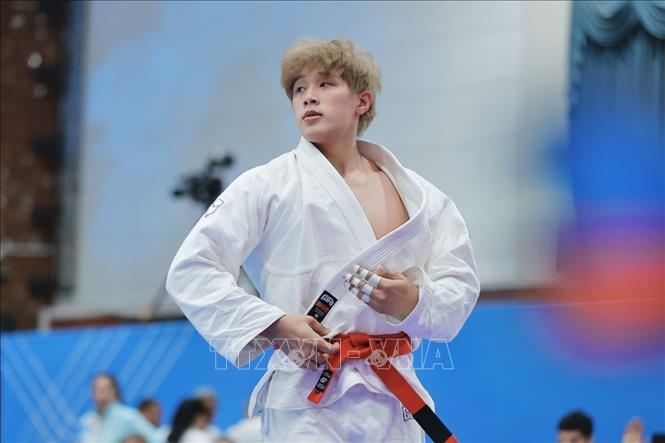 VĐV Nguyễn Tiến Triển (đai đỏ, Việt Nam) thi đấu nội dung Ne-waza hạng 85kg. Ảnh: Minh Quyết - PV TTXVN tại Thái Lan