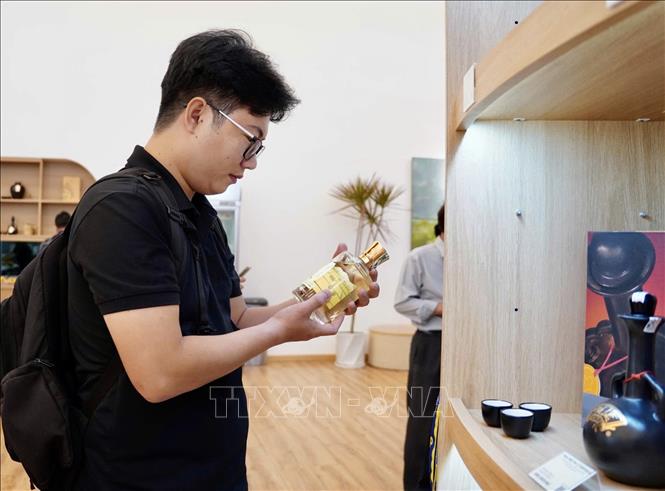 Sinh viên tìm hiểu về sản phẩm mới của Công ty CP Rượu Phú Lễ. Ảnh: Mỹ Phương - TTXVN
