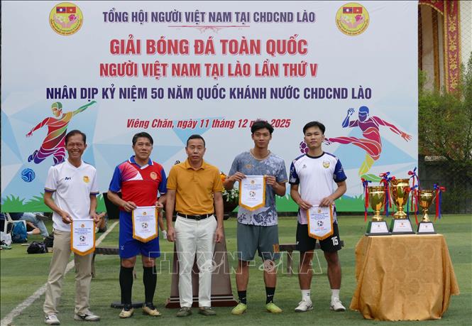Đại diện Tổng hội người Việt Nam tại Lào trao cờ lưu niệm cho các đội tham dự giải đấu. Ảnh: Xuân Tú - PV TTXVN tại Lào