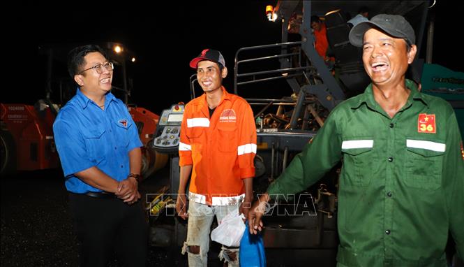 Anh Trần Việt Tuấn, Phó Bí thư Thành đoàn Cần Thơ thăm hỏi, động viên công nhân thi công ca đêm. Ảnh: Hồng Thái - TTXVN