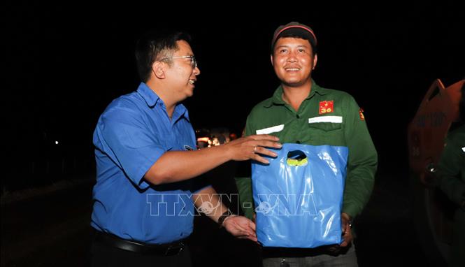 Anh Trần Việt Tuấn, Phó Bí thư Thành đoàn Cần Thơ trao quà đến công nhân thi công ca đêm. Ảnh: Hồng Thái - TTXVN
