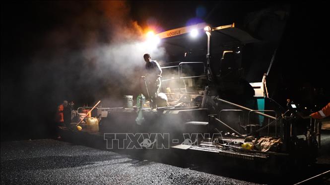 Công nhân thi công ca đêm với quyết tâm thông xe kỹ thuật cao tốc Cần Thơ - Cà Mau trước ngày 19/12. Ảnh: Hồng Thái - TTXVN