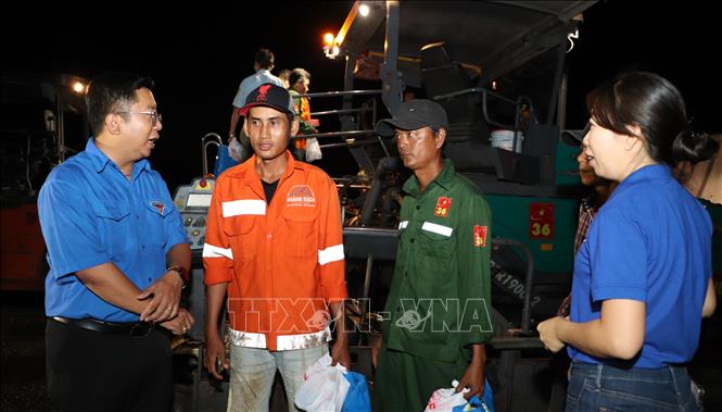 Anh Trần Việt Tuấn, Phó Bí thư Thành đoàn Cần Thơ thăm hỏi, động viên công nhân thi công ca đêm. Ảnh: Hồng Thái - TTXVN