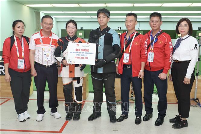 Trưởng đoàn Thể thao Việt Nam Nguyễn Hồng Minh động viên hai xạ thủ vừa đoạt HCV. Ảnh: TTXVN phát