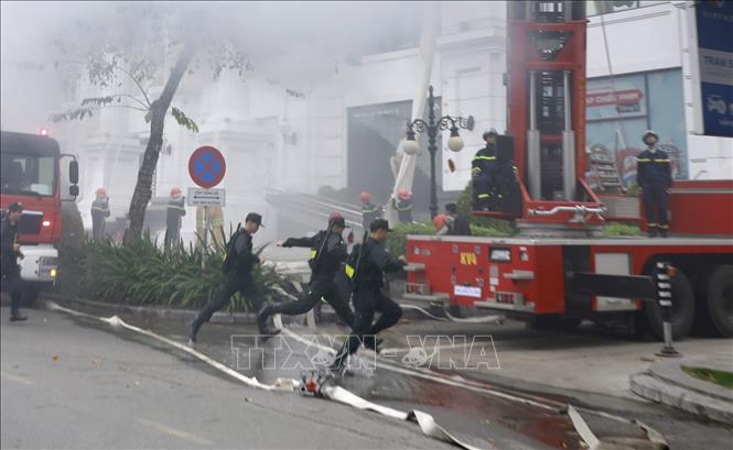 Lưc lượng cảnh sát cơ động có mặt tại hiện trường tham gia chữa cháy tại đám cháy. Ảnh: Hoàng Hùng -TTXVN
