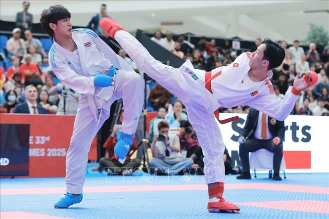 Võ sĩ Khuất Hải Nam (đai đỏ) xuất sắc đánh bại võ sĩ nước chủ nhà để giành HCV nội dung Kumite hạng cân dưới 67kg. Ảnh: Minh Quyết - PV TTXVN tại Thái Lan 