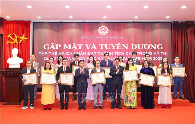 Thứ trưởng Bộ GD&ĐT Lê Quân và Cục trưởng Huỳnh Văn Chương trao Bằng khen cho các cá nhân có thành tích xuất sắc trong công tác tập huấn, giảng dạy, bồi dưỡng và dẫn đoàn học sinh dự thi đoạt giải. Ảnh: Thanh Tùng - TTXVN