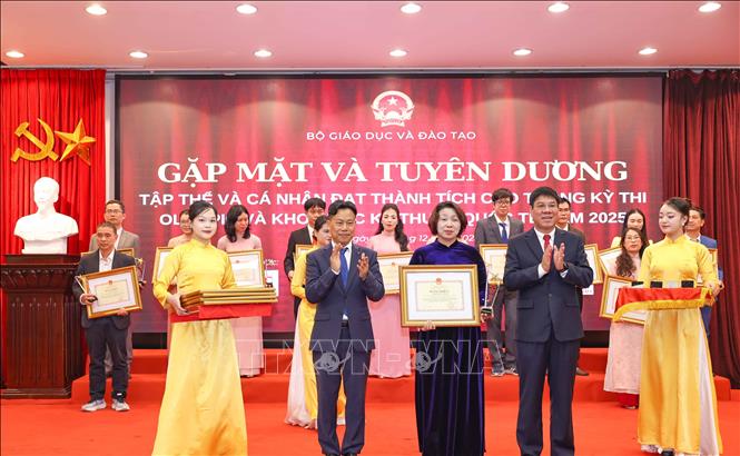 Thứ trưởng Bộ GD&ĐT Lê Quân và Cục trưởng Huỳnh Văn Chương trao Bằng khen cho các cá nhân có thành tích xuất sắc trong công tác tập huấn, giảng dạy, bồi dưỡng và dẫn đoàn học sinh dự thi đoạt giải. Ảnh: Thanh Tùng - TTXVN