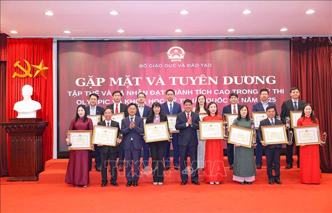 Thứ trưởng Bộ GD&ĐT Lê Quân và ông Huỳnh Văn Chương, Cục trường Cục Quản lý chất lượng (Bộ GD&ĐT) trao Bằng khen, kỷ niệm chương cho các tập thể có thành tích xuất sắc trong công tác tập huấn, giảng dạy, bồi dưỡng và dẫn đoàn học sinh dự thi đoạt giải các kỳ thi Olympic quốc tế các môn học và thi nghiên cứu KHKT quốc tế năm 2025. Ảnh: Thanh Tùng - TTXVN 